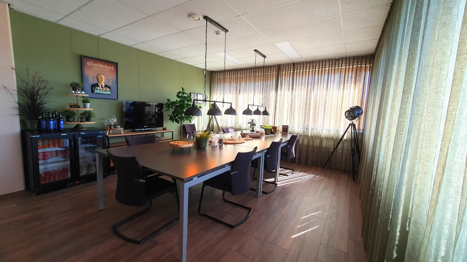 De greenroom met de grote tafel, het afkijkscherm en de pantry