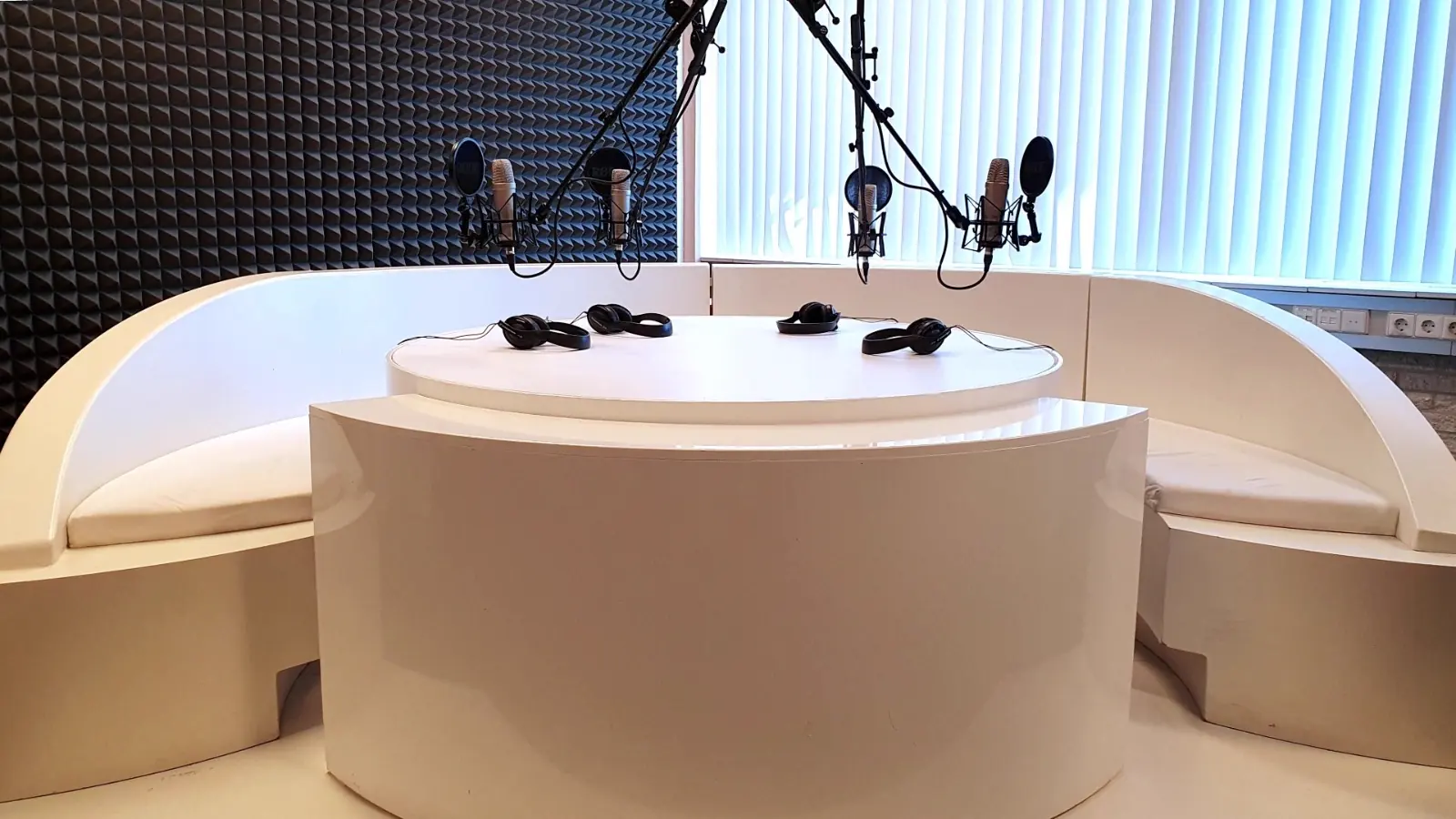 Studio B: de ronde podcasttafel met vier microfoons en koptelefoons